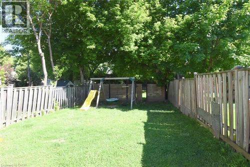 Expansive backyard with a lush lawn, mature trees, and privacy fencing - 12 Wood Street W, Hamilton, ON - Outdoor