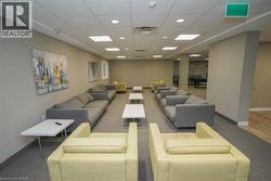 Spacious common area featuring textured carpeting, neutral wall tones, recessed lighting, and a drop ceiling - 