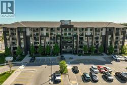 Contemporary multi-story building featuring a dark brick and light-colored façade, multiple private balconies with glass railings, a pitched roof, and a prominent front entrance - 