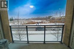 Balcony featuring glass panel railings, brick exterior columns, and a concrete surface - 
