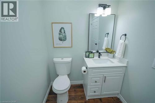 Contemporary bathroom featuring a white vanity with a quartz countertop and integrated sink, matte black faucet, and a rectangular mirror with a three-light fixture above - 7 Kay Crescent Unit# 107, Guelph, ON 