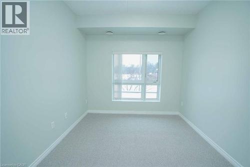Carpeted room with light-toned walls and a large window - 7 Kay Crescent Unit# 107, Guelph, ON 
