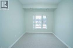 Carpeted room with light-toned walls and a large window - 
