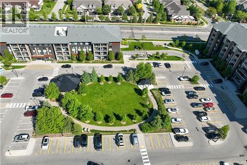 Modern multi-story building featuring dark exterior cladding and grey gabled roofing - 7 Kay Crescent Unit# 107, Guelph, ON 