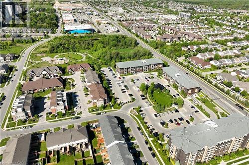 Aerial perspective featuring a residential community with varied architectural styles, including multi-story buildings and townhome configurations - 7 Kay Crescent Unit# 107, Guelph, ON 