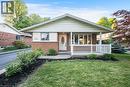 Brick and siding exterior featuring a covered front porch with white railings, a bay window, and a paved driveway - 124 Dunsmere Drive, Kitchener, ON  - Outdoor With Deck Patio Veranda 