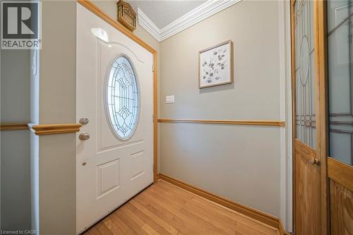 Entryway featuring a white door with an oval leaded glass insert, natural wood-finish flooring, light gray walls, and crown molding - 124 Dunsmere Drive, Kitchener, ON - Indoor Photo Showing Other Room