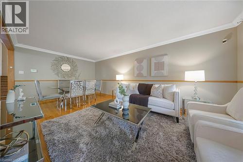 Open-concept living space featuring wood-finish flooring, crown molding, and a neutral color palette - 124 Dunsmere Drive, Kitchener, ON - Indoor Photo Showing Living Room