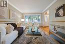 Bright living area featuring a bay window, crown molding, chair rail detailing, wood-finish flooring, and a decorative front entry door with an oval glass insert - 124 Dunsmere Drive, Kitchener, ON  - Indoor Photo Showing Living Room 