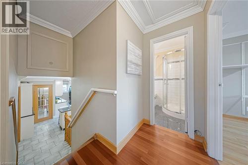 Hardwood flooring in a central hallway featuring crown molding and a built-in linen cupboard - 124 Dunsmere Drive, Kitchener, ON - Indoor Photo Showing Other Room