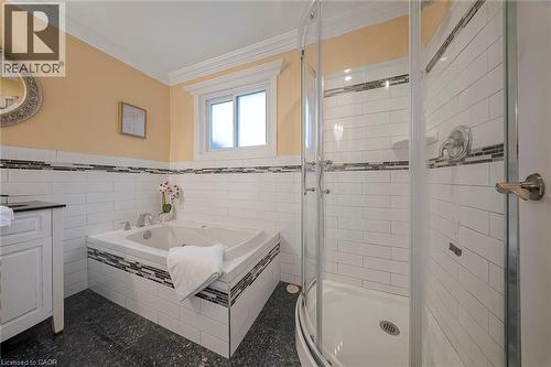 Bathroom featuring a corner soaking tub with subway tile surround and decorative mosaic accent - 124 Dunsmere Drive, Kitchener, ON - Indoor Photo Showing Bathroom