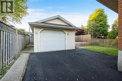Detached garage featuring a paneled door, vinyl siding, and shingle roofing - 124 Dunsmere Drive, Kitchener, ON - Outdoor