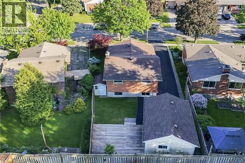 Brick exterior residence featuring a detached garage, a rear wooden deck, and a fenced backyard - 124 Dunsmere Drive, Kitchener, ON - Outdoor
