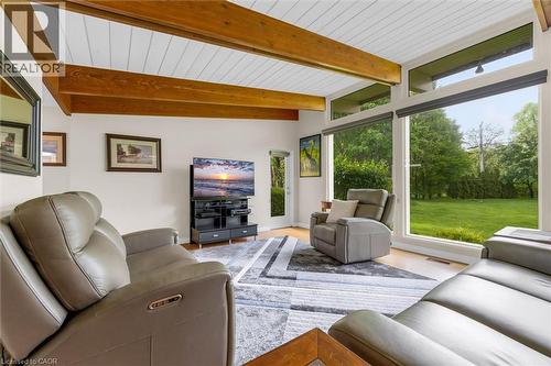 Living area featuring exposed wood beams, wood-finish flooring, and expansive windows - 899 Niagara Parkway, Fort Erie, ON 