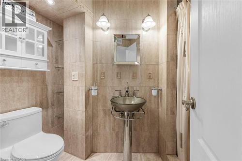 3 piece w sep shower Tiled bathroom featuring a pedestal sink with vessel bowl, wall-mounted mirror, and sconce lighting - 899 Niagara Parkway, Fort Erie, ON 