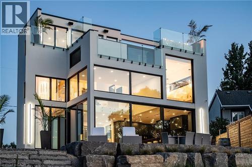Modern architectural exterior featuring multiple levels, extensive glazing, glass railings on upper balconies, and integrated vertical lighting fixtures - 6 Firelane 11A Street, Niagara-On-The-Lake, ON - Outdoor