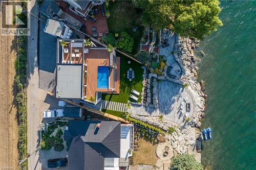 Waterside property featuring a multi-level rock and stone patio, a private dock, an artificial turf lawn, a deck with an integrated swimming pool, and a rooftop terrace - 6 Firelane 11A Street, Niagara-On-The-Lake, ON - Outdoor With Body Of Water