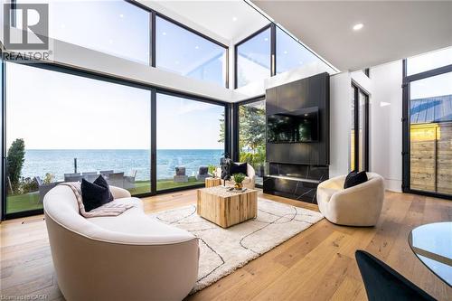 Open-concept living space with expansive floor-to-ceiling windows overlooking a substantial body of water - 6 Firelane 11A Street, Niagara-On-The-Lake, ON - Indoor
