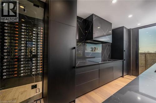 Sleek modern kitchen featuring black slab cabinetry and black countertops with white veining - 6 Firelane 11A Street, Niagara-On-The-Lake, ON - Indoor