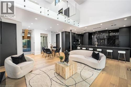 Open-concept living space featuring light wood-finish flooring, a two-story ceiling, and a glass-paneled upper-level railing - 6 Firelane 11A Street, Niagara-On-The-Lake, ON - Indoor