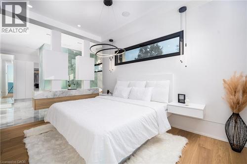 Contemporary bedroom featuring a wood-finish floor and a built-in floating nightstand - 6 Firelane 11A Street, Niagara-On-The-Lake, ON - Indoor Photo Showing Bedroom