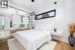Contemporary bedroom featuring a wood-finish floor and a built-in floating nightstand - 