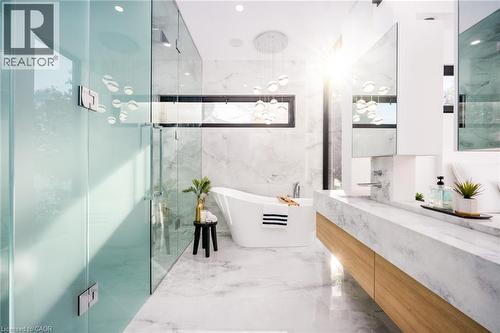 Spacious bathroom featuring a freestanding tub, expansive dual vanity with wood-finish cabinetry, and a large walk-in shower with frosted and clear glass panels - 6 Firelane 11A Street, Niagara-On-The-Lake, ON - Indoor Photo Showing Bathroom