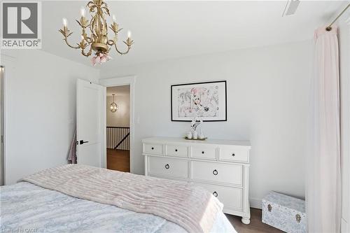 White interior space featuring a multi-bulb chandelier with ornate gold-tone detailing - 71 Miles Road, Hamilton, ON 