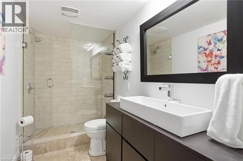 Modern bathroom featuring a frameless glass shower enclosure, beige tile shower surround, and a rectangular vessel sink - 71 Miles Road, Hamilton, ON 