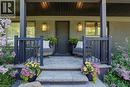 Covered front porch featuring a dark gray door and complementary exterior lighting - 71 Miles Road, Hamilton, ON 