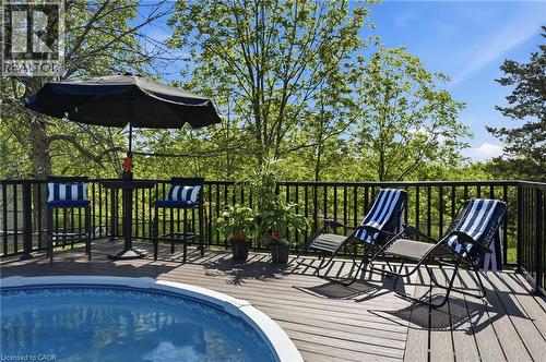 Outdoor decking with a built-in circular pool, surrounded by a black railing - 71 Miles Road, Hamilton, ON 