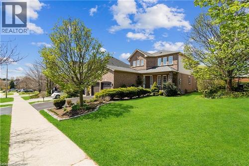 Brick exterior with a dark-pitched roof, featuring multiple windows - 106 Moore Crescent, Ancaster, ON 