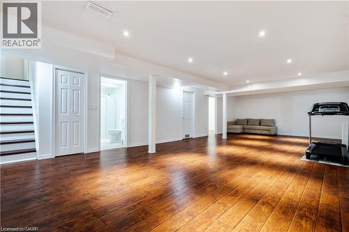 Spacious lower-level area featuring wood-finish flooring, recessed lighting, and white walls - 106 Moore Crescent, Ancaster, ON 