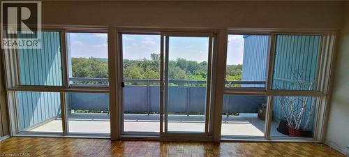 Expansive wall of windows with sliding glass doors opening to a private balcony - 105 Conroy Crescent Unit# 505, Guelph, ON 