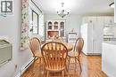 Dining area featuring wood-finish flooring, a decorative chandelier, and a window with natural light - 29 West Avenue, Kitchener, ON 