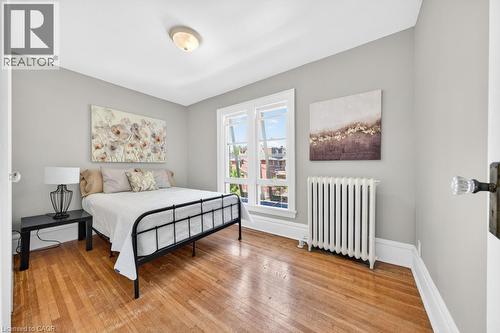 Hardwood flooring throughout featuring white baseboards, trim, and window casings - 35 Burris Street, Hamilton, ON - Indoor Photo Showing Bedroom