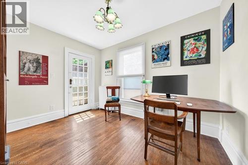 Hardwood flooring spans this room featuring a multi-pane glass door, white trim, and a ceiling-mounted light fixture - 35 Burris Street, Hamilton, ON - Indoor Photo Showing Office