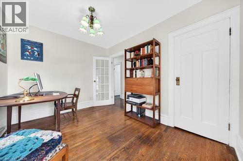 Hardwood flooring throughout, white baseboards, and a white interior door with brass hardware - 35 Burris Street, Hamilton, ON - Indoor