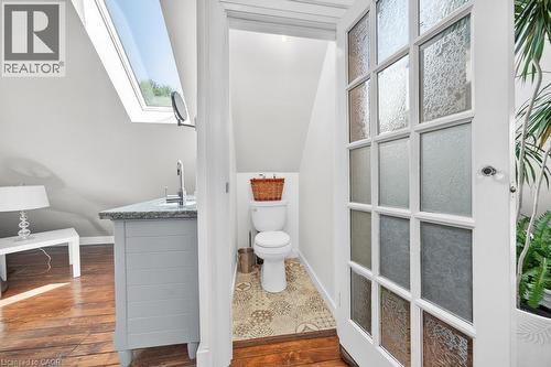 Vanity area featuring a skylight, wood-finish flooring, and a vanity with a stone countertop - 35 Burris Street, Hamilton, ON - Indoor Photo Showing Bathroom