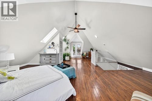 Spacious upper-level room featuring wood-finish flooring, vaulted ceilings, and a ceiling fan - 35 Burris Street, Hamilton, ON - Indoor Photo Showing Bedroom