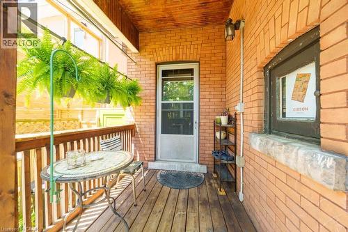 Inviting outdoor balcony featuring a wood-finish floor and a brick exterior wall - 35 Burris Street, Hamilton, ON - Outdoor With Deck Patio Veranda With Exterior