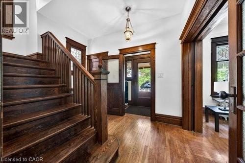 Dark wood-finish staircase with matching banister and newel post - 35 Burris Street, Hamilton, ON - Indoor Photo Showing Other Room