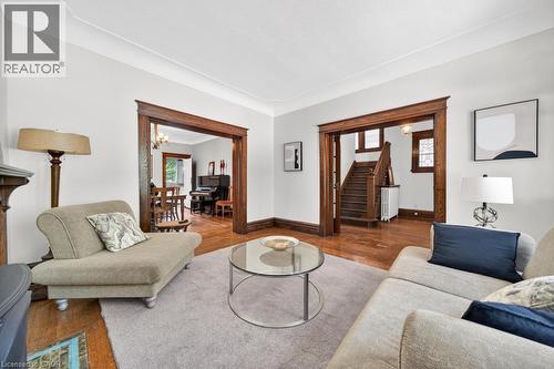 Hardwood flooring throughout the main living areas, featuring wide wooden trim and crown molding - 35 Burris Street, Hamilton, ON - Indoor Photo Showing Living Room