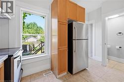 Kitchen featuring a stainless steel refrigerator, light wood-finish cabinetry - 
