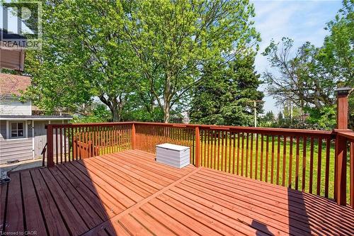 Expansive wood-finish deck featuring a warm stain, sturdy balusters, and a backyard area with mature trees - 43 West 1St Street, Hamilton, ON 