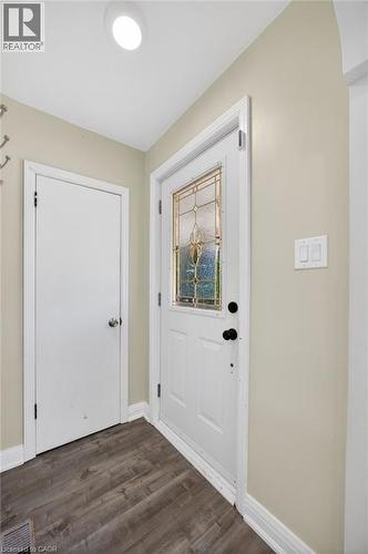 Entryway featuring a white door with decorative glass inserts, wood-finish flooring, and light-toned wall paint - 43 West 1St Street, Hamilton, ON 