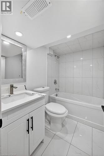 Contemporary bathroom featuring a white vanity with black hardware, a rectangular sink, and a brushed nickel faucet - 43 West 1St Street, Hamilton, ON 