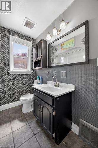 Bathroom featuring a single vanity with a white countertop and dark cabinetry - 43 West 1St Street, Hamilton, ON 