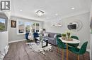 Open concept living area featuring wood-finish flooring, a tray ceiling with recessed lighting, and a modern chandelier - 43 West 1St Street, Hamilton, ON 