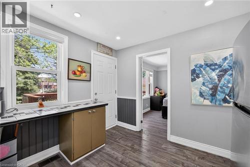 Functional utility space featuring wood-finish flooring and a window overlooking exterior foliage - 43 West 1St Street, Hamilton, ON 